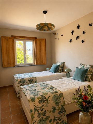 The second bedroom, with two single beds and a shuttered window